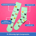 Light green knee high compression socks with cat design flat lay