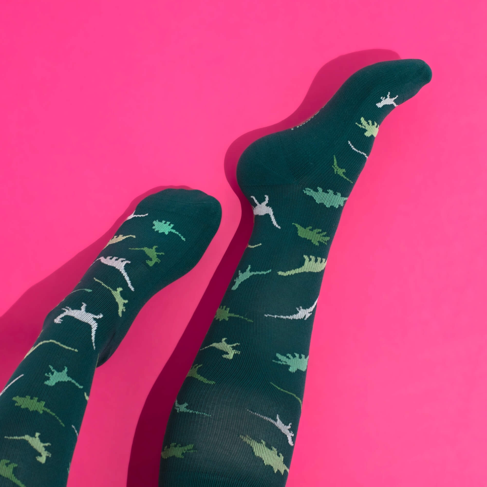Green compression socks with a dinosaur pattern