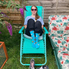 Woman sitting in chair wearing Teal knee high compression socks with dog pattern